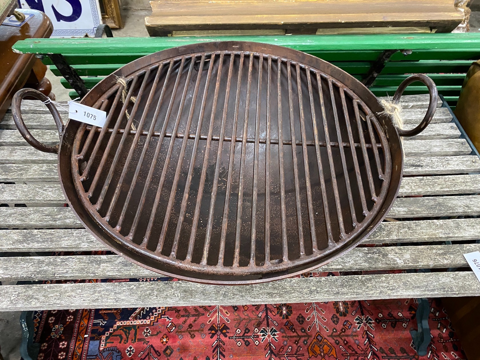 A circular wrought iron fire-pit on low stand, diameter 82cm, height 38cm